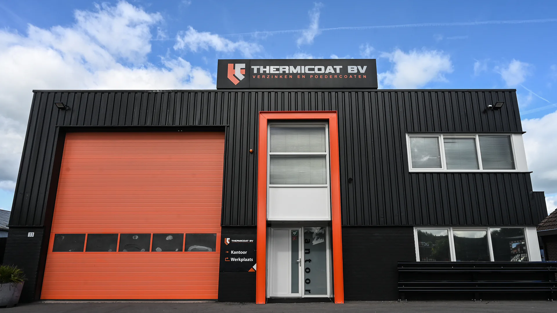 De gevel van Thermicoat BV aan de Mercuriusweg in Brummen, met naambord en oranje deur
