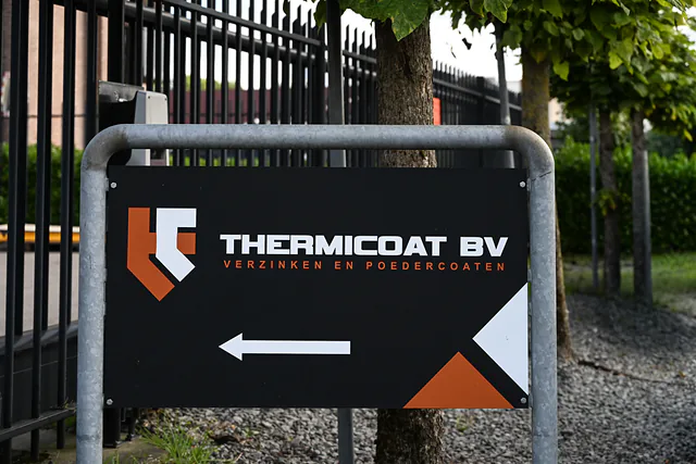 Verwijsbord van Thermicoat BV bij de inrit, met pijl naar het pand