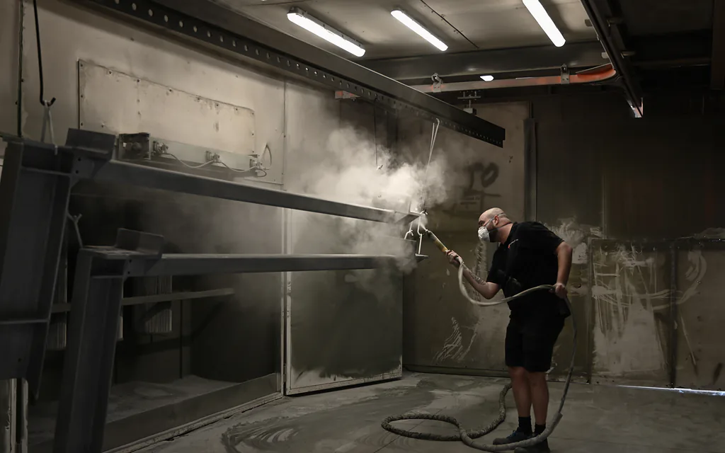 Coater spuit een stalen ligger in de spuitcabine van Thermicoat