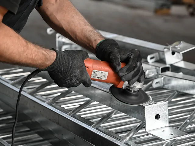 Zinkpunten worden met een slijper weggewerkt op een verzinkt frame
